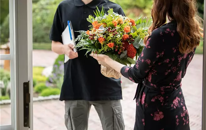 Lieferservice - Lieferant übergibt Blumenstrauß
