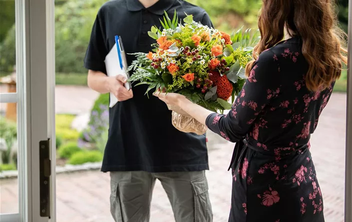 Lieferservice - Lieferant übergibt Blumenstrauß